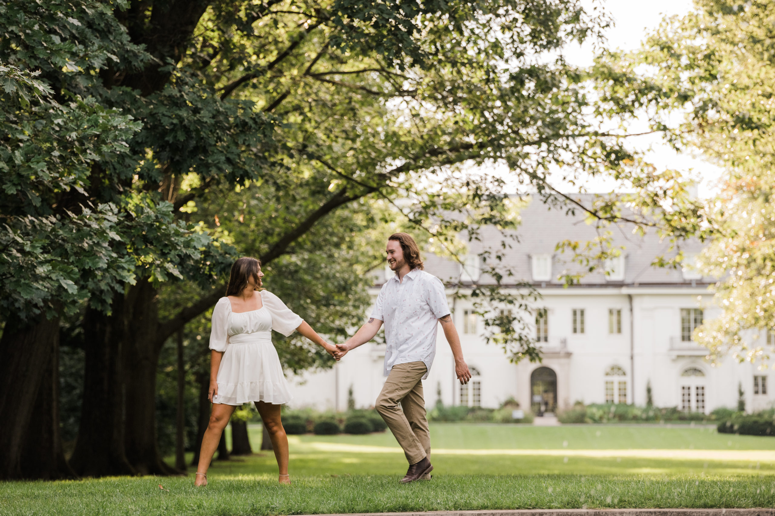 bride-to-be leads her fiancée in an engagement picture captured at Newfields in Indianapolis.