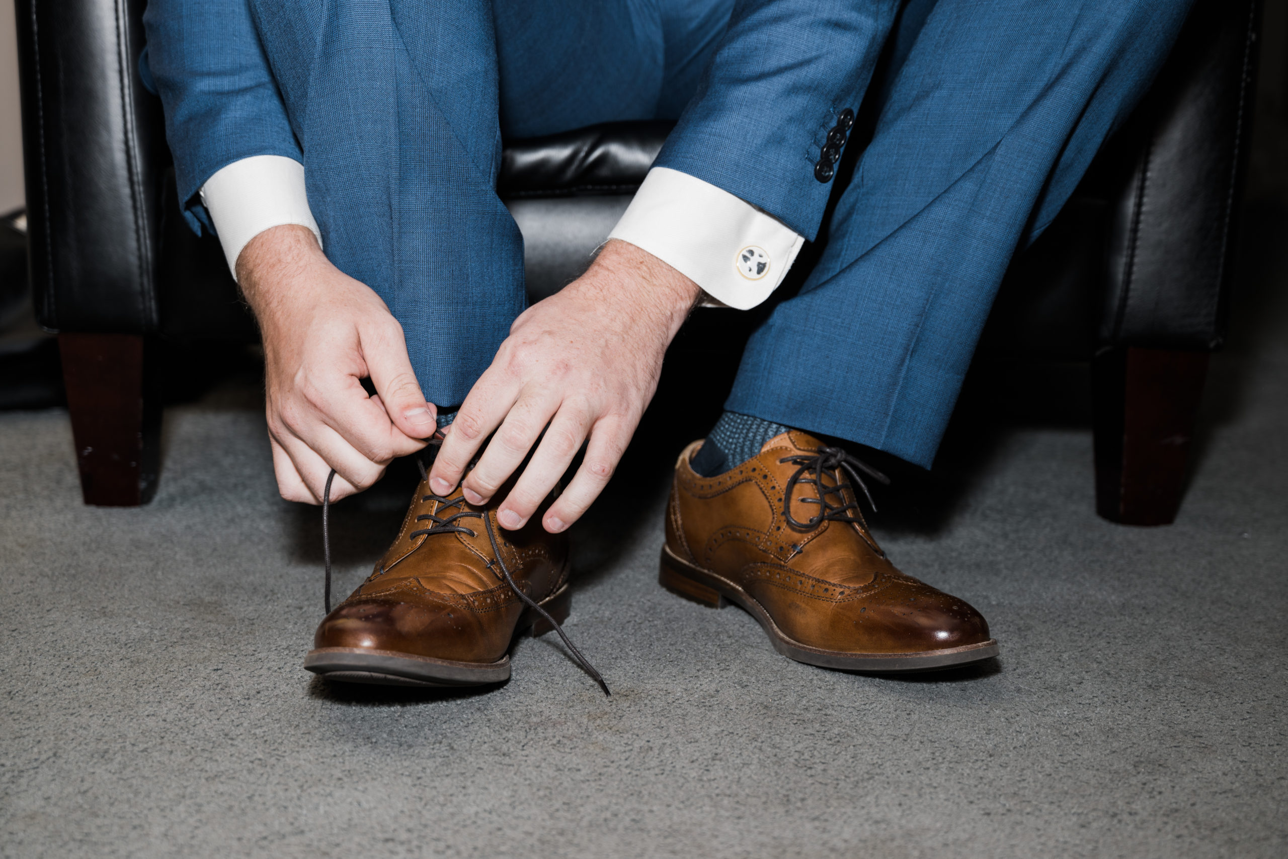 Groom tying shoes Black Iris wedding Carmel, Indiana